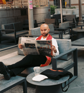 Picture of Emanuel holding a copy of Daily Trojan